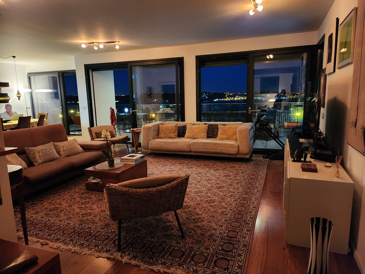 Sala ao anoitecer com vista para as luzes da cidade