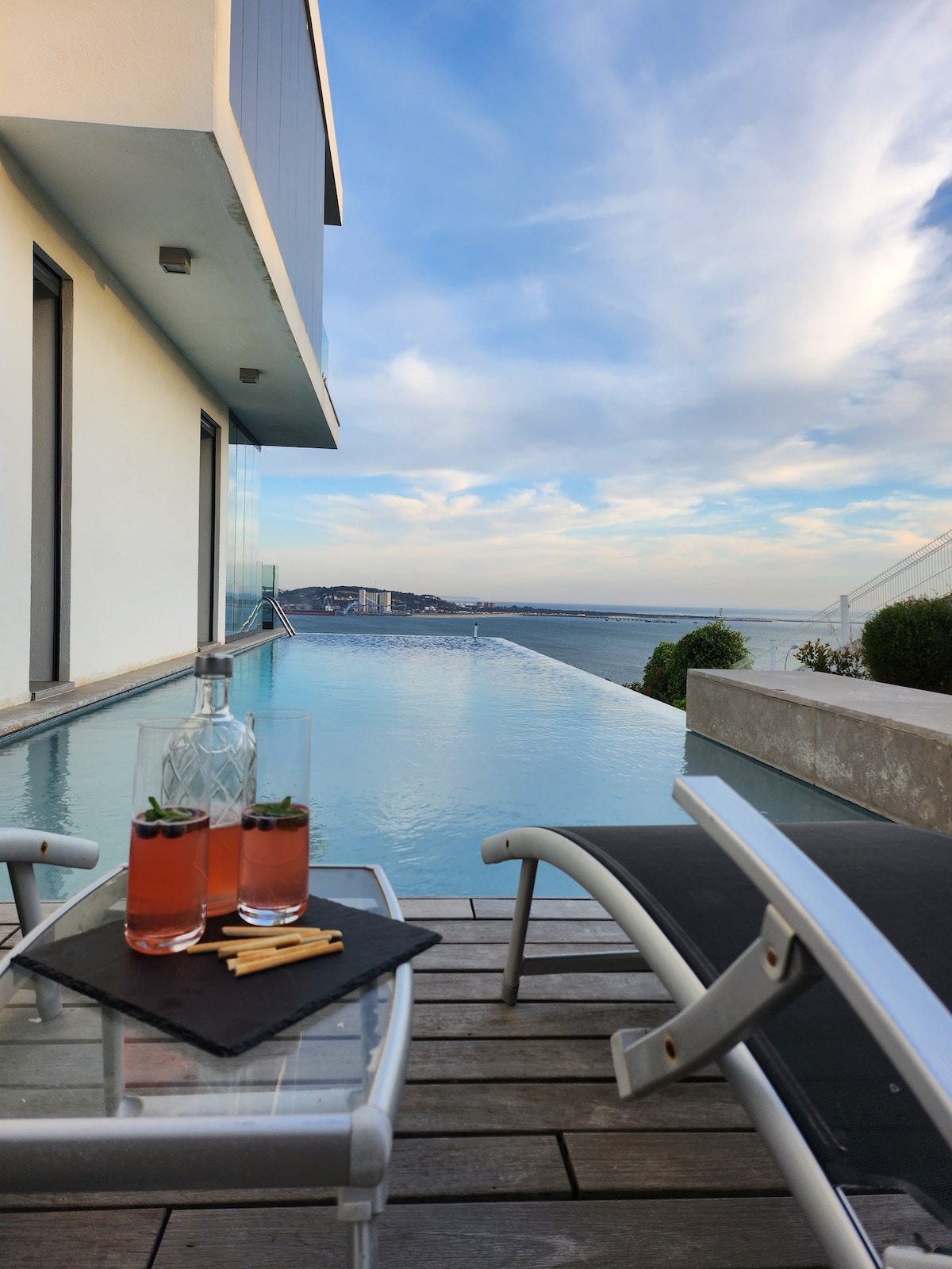 Terraço da piscina com espreguiçadeiras e vista para o rio