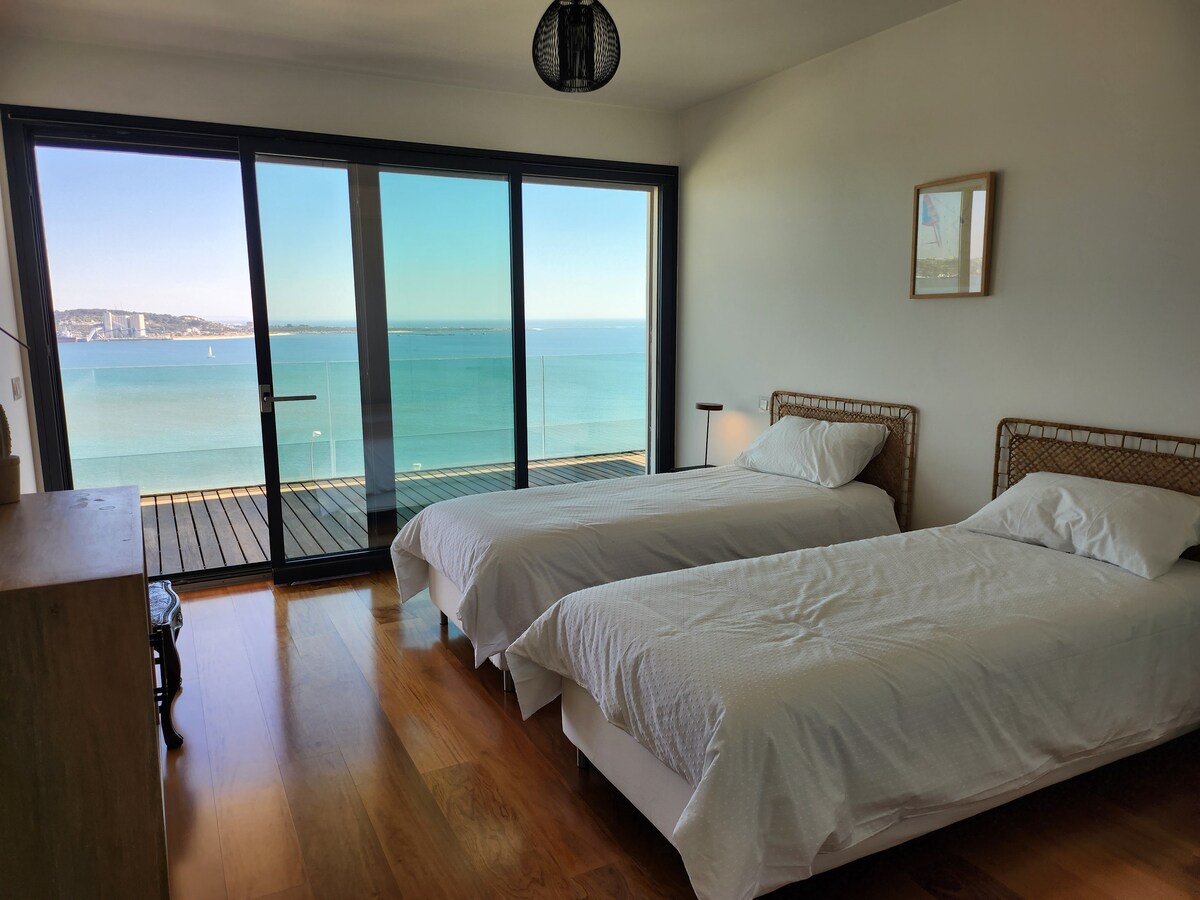 Quarto com duas camas e janelas panorâmicas para o rio